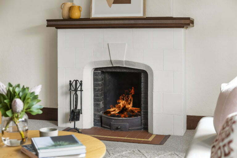 a fireplace with a wood table and books in front of it