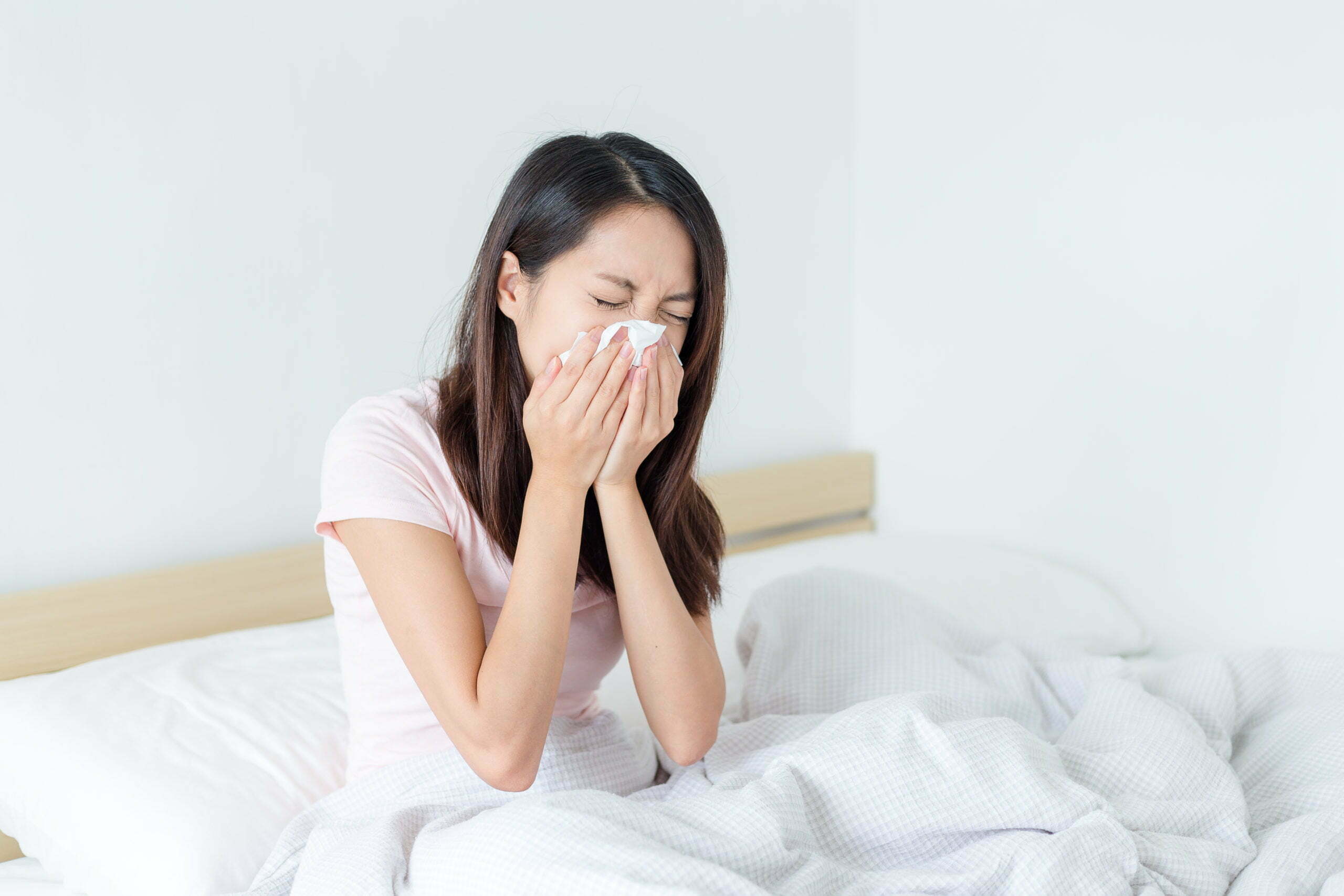 a woman lying in bed with her hand on her face