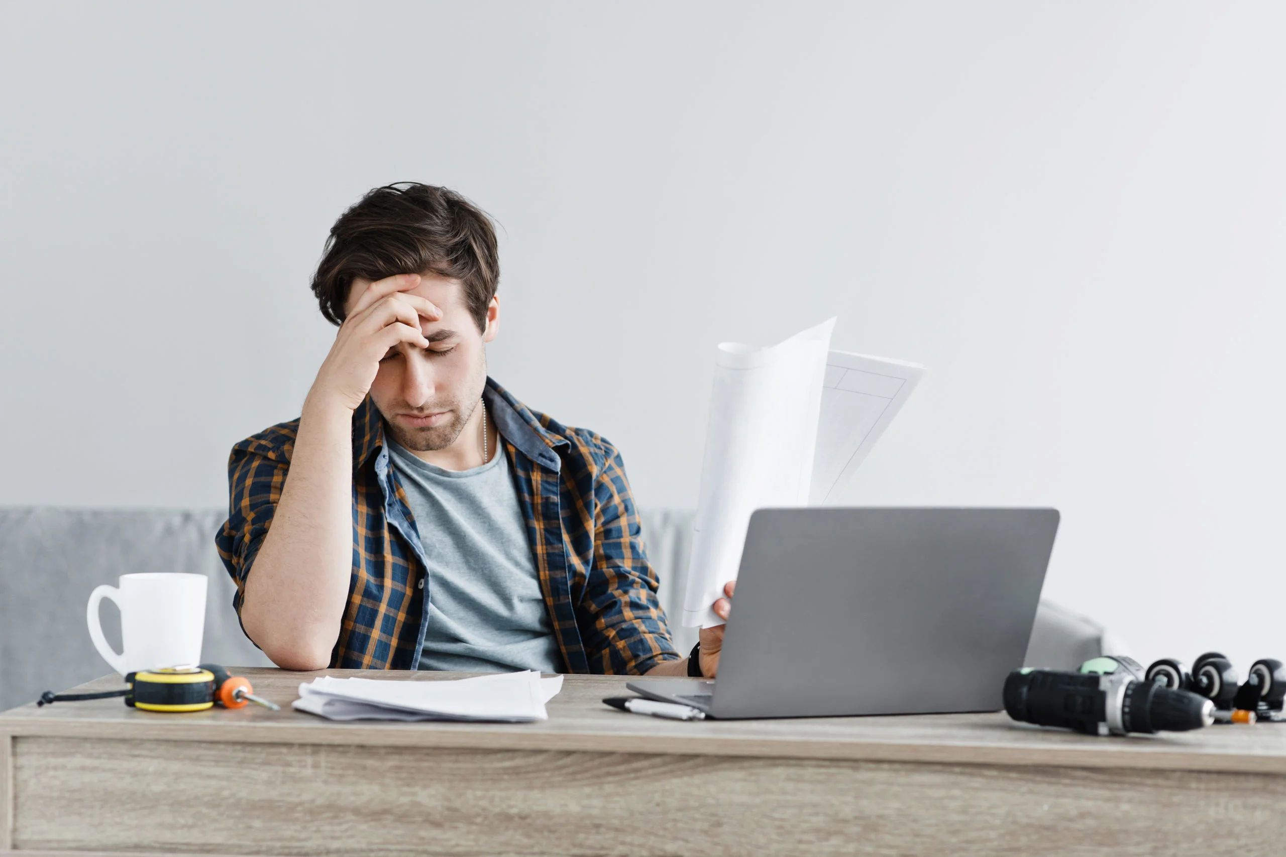 a person sitting at a desk with a laptop and headphones