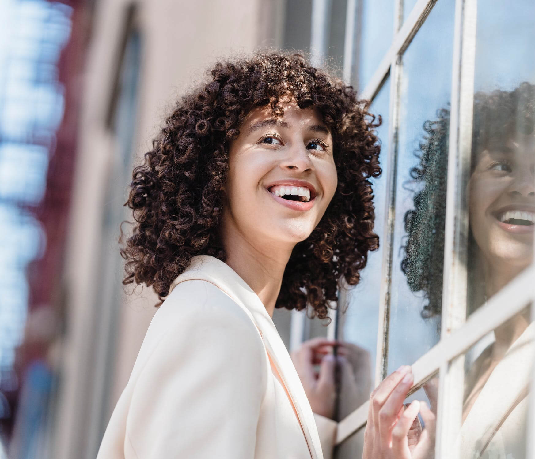 a person smiling and standing next to a window